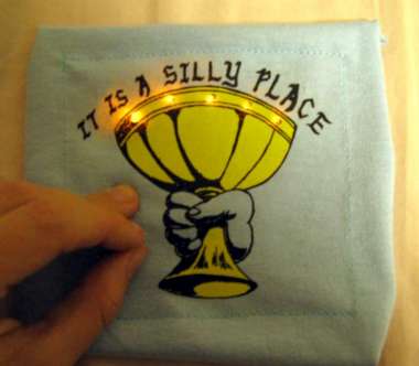 square of fabric with finger pushing and LEDs shining
